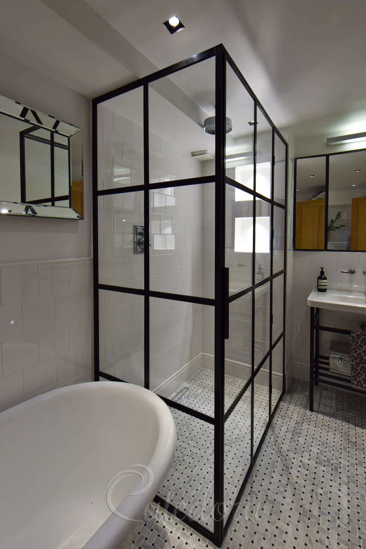 Black grid corner shower enclosure with walk-in floor and subway tiles