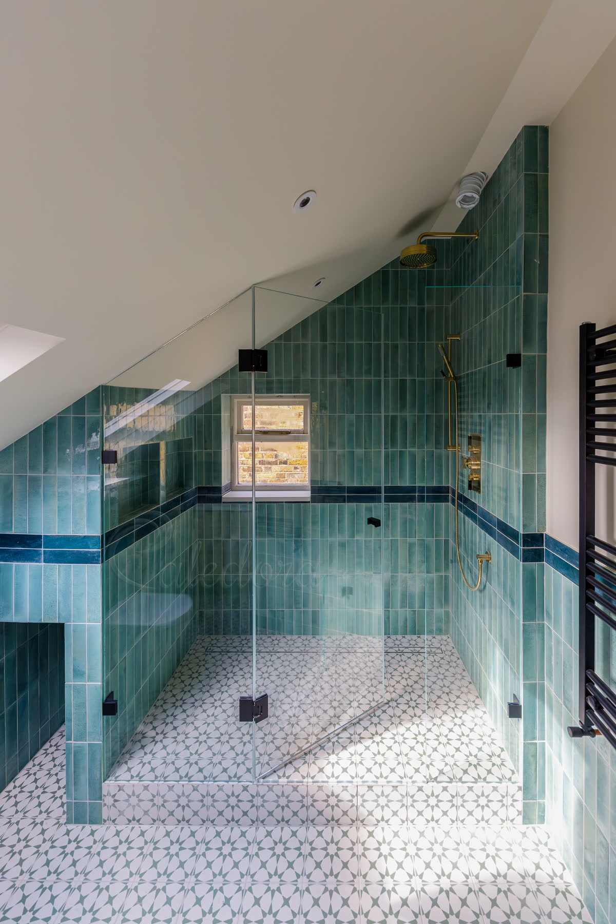 Black frameless shower door with angled panel in a loft bathroom