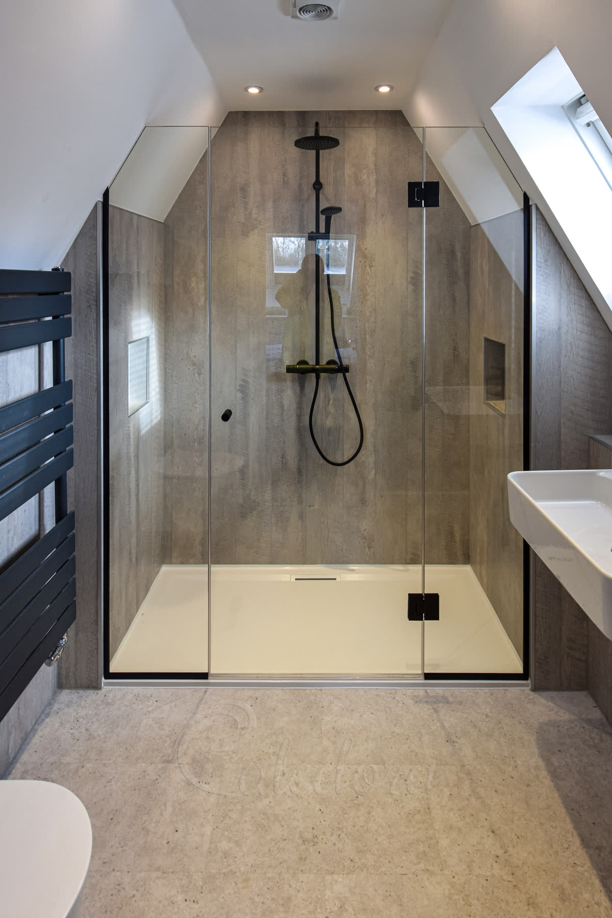 Frameless black shower enclosure under loft eaves with centre door