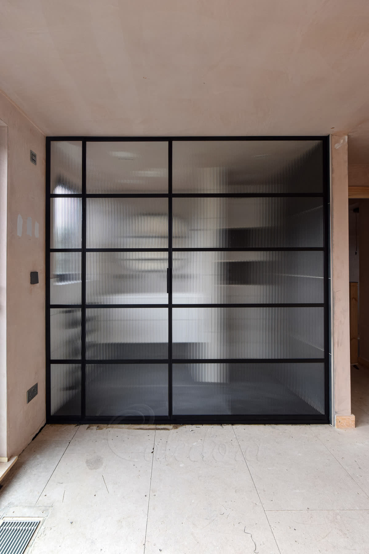 Reeded glass shower screen in a black grid frame beside a fixed inline panel