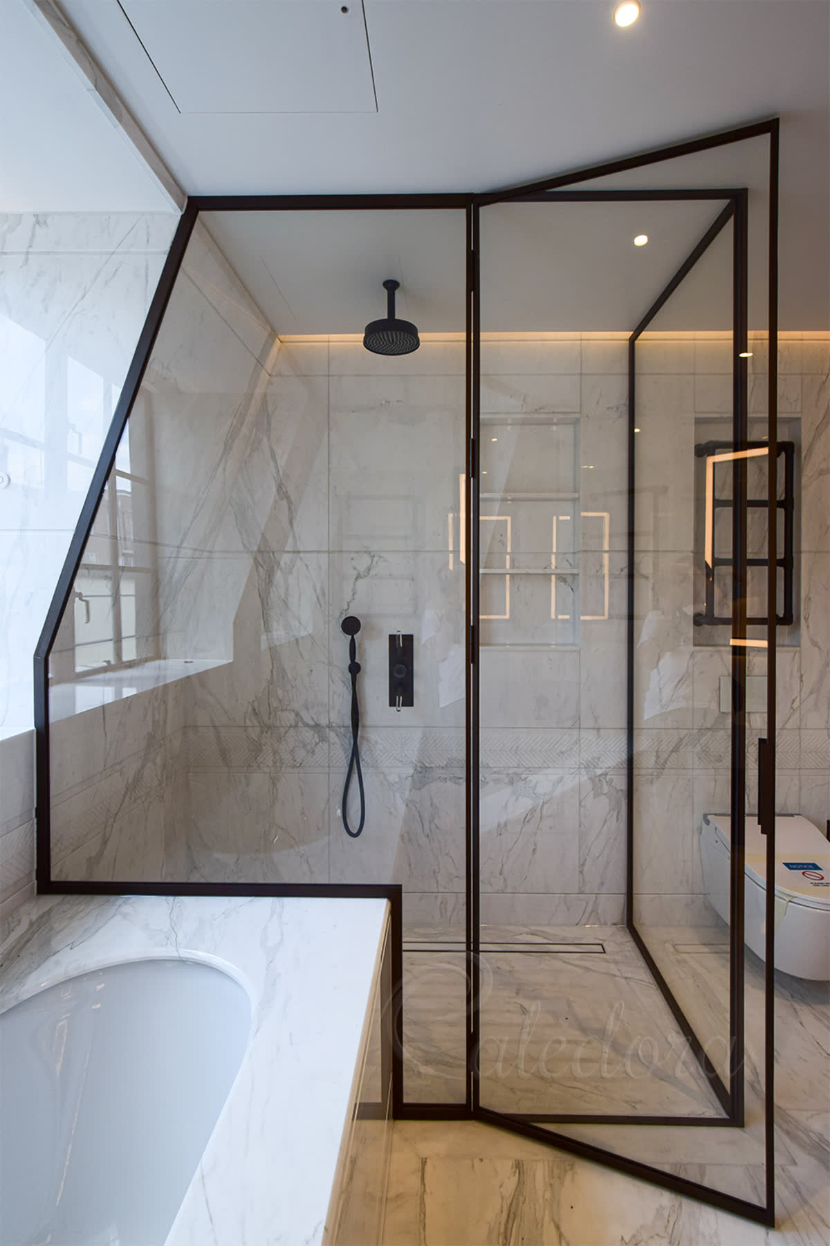 shower enclosure with bronze frame and slanted ceiling