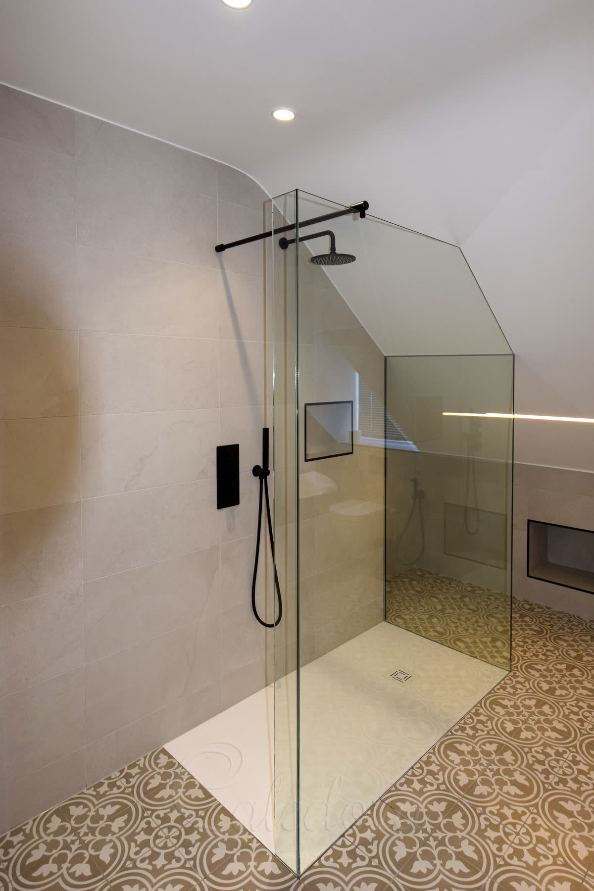 Custom shower screen three-sided walk-in with return panel and one side shaped to follow loft ceiling line with black fixtures