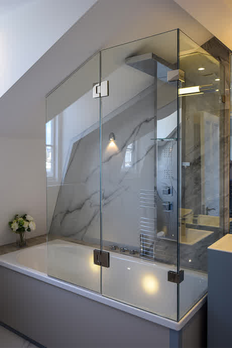 custom bath screen with shaped hinged panel surrounding the bath on two sides