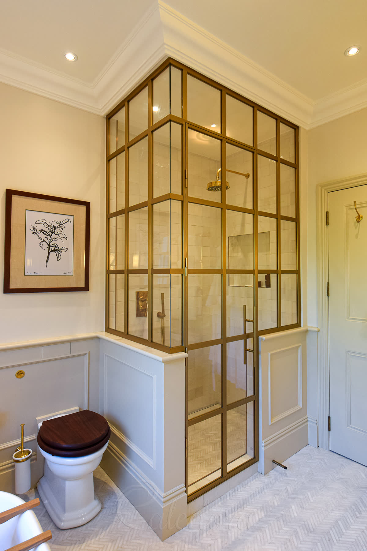 Brushed-gold frameless glass shower enclosure with full-height door in a luxury London bathroom