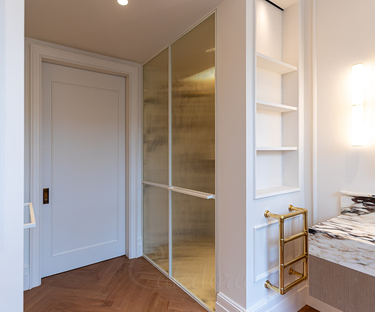 White powder-coated framed shower door with 4+4mm laminated fluted glass and horizontal divider bar in a London bathroom
