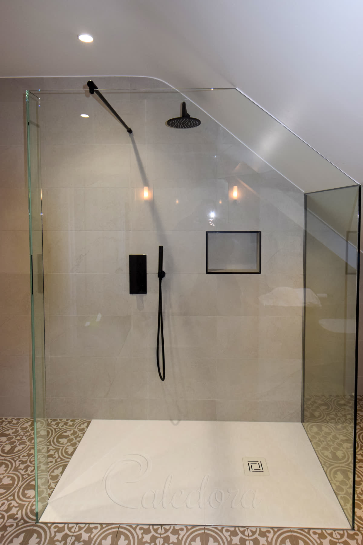 UV-bonded glass-to-glass connections in loft angled shower screen with tiled walls