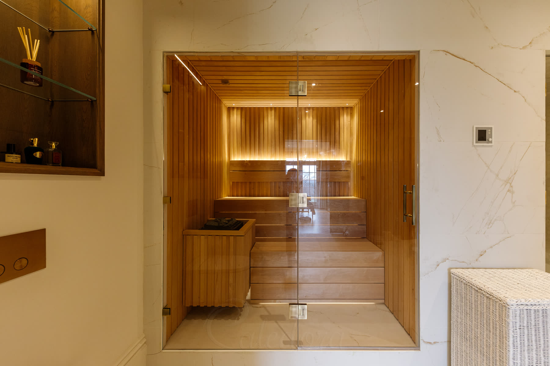 Full front view of sauna with frameless glass door and timber cladding