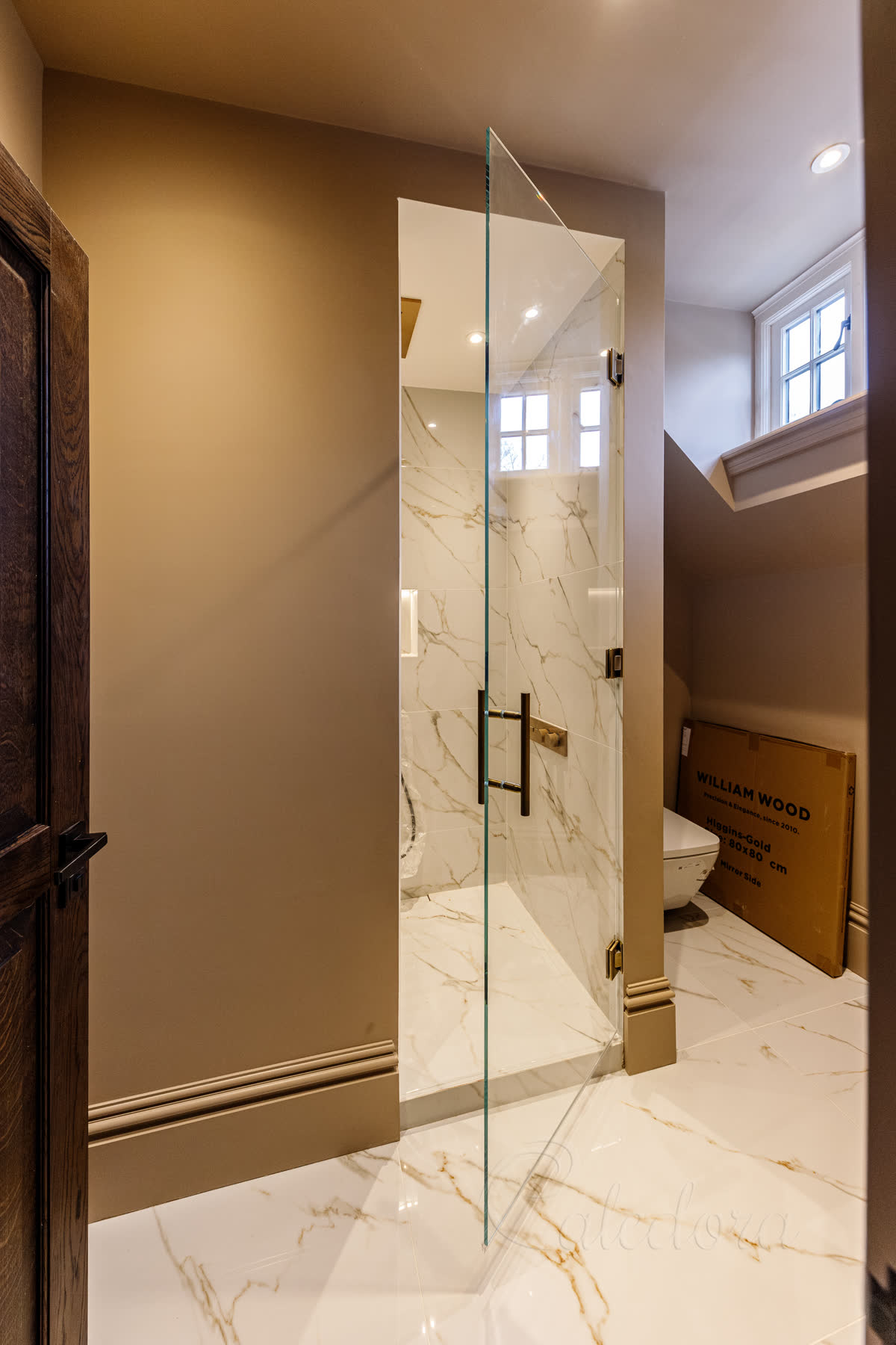 Same second bathroom door opened a few degrees showing the slight blue tone at the cut edge of 10mm ultra clear glass against the marble