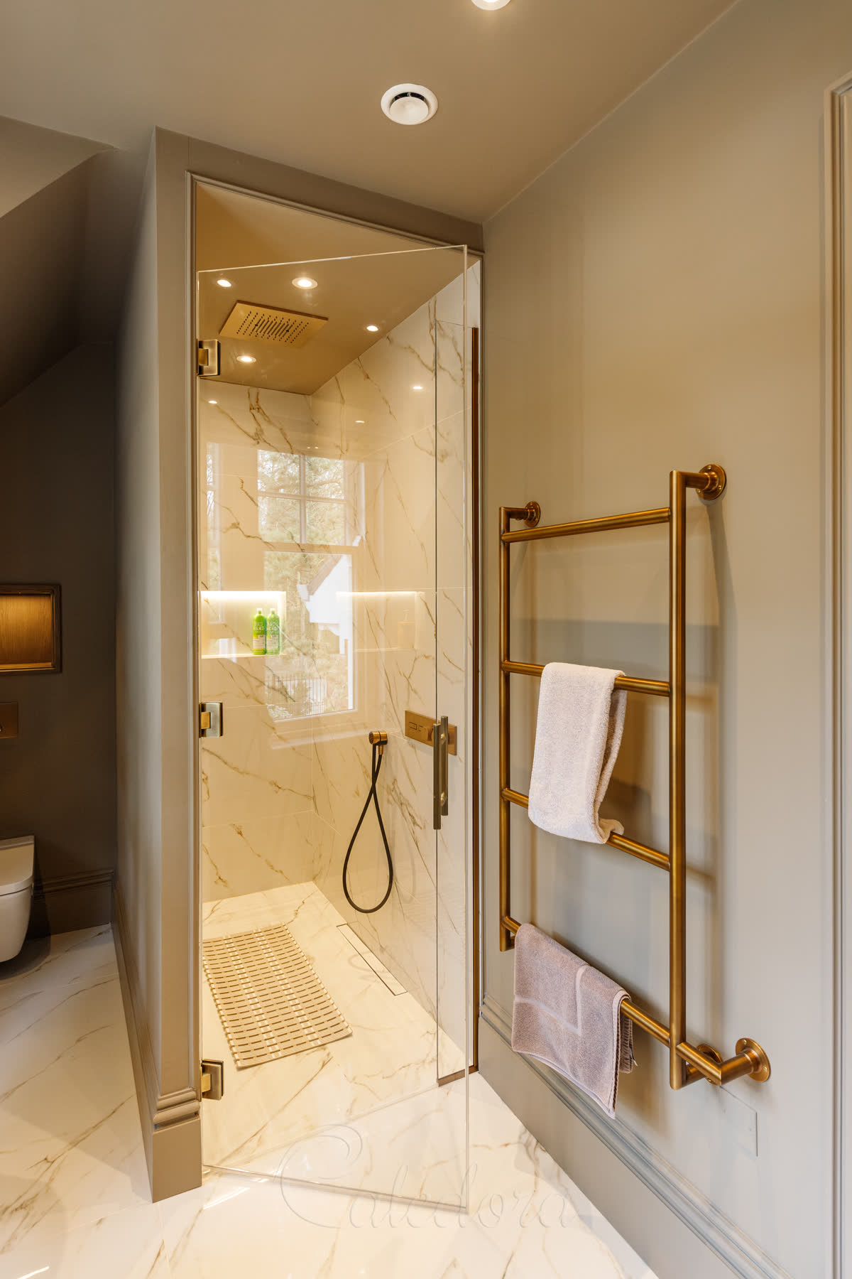 Antique brass swing shower door opened outward with the antique brass towel heater within reach beside the opening
