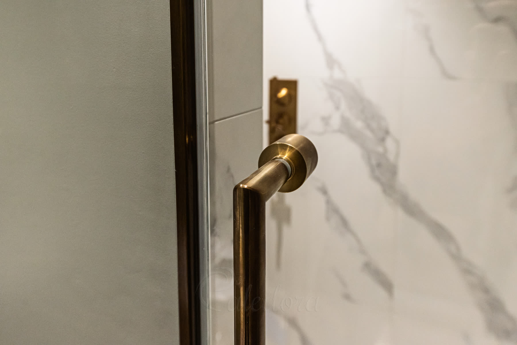 Close-up of antique brass shower door rail handle with elegant design