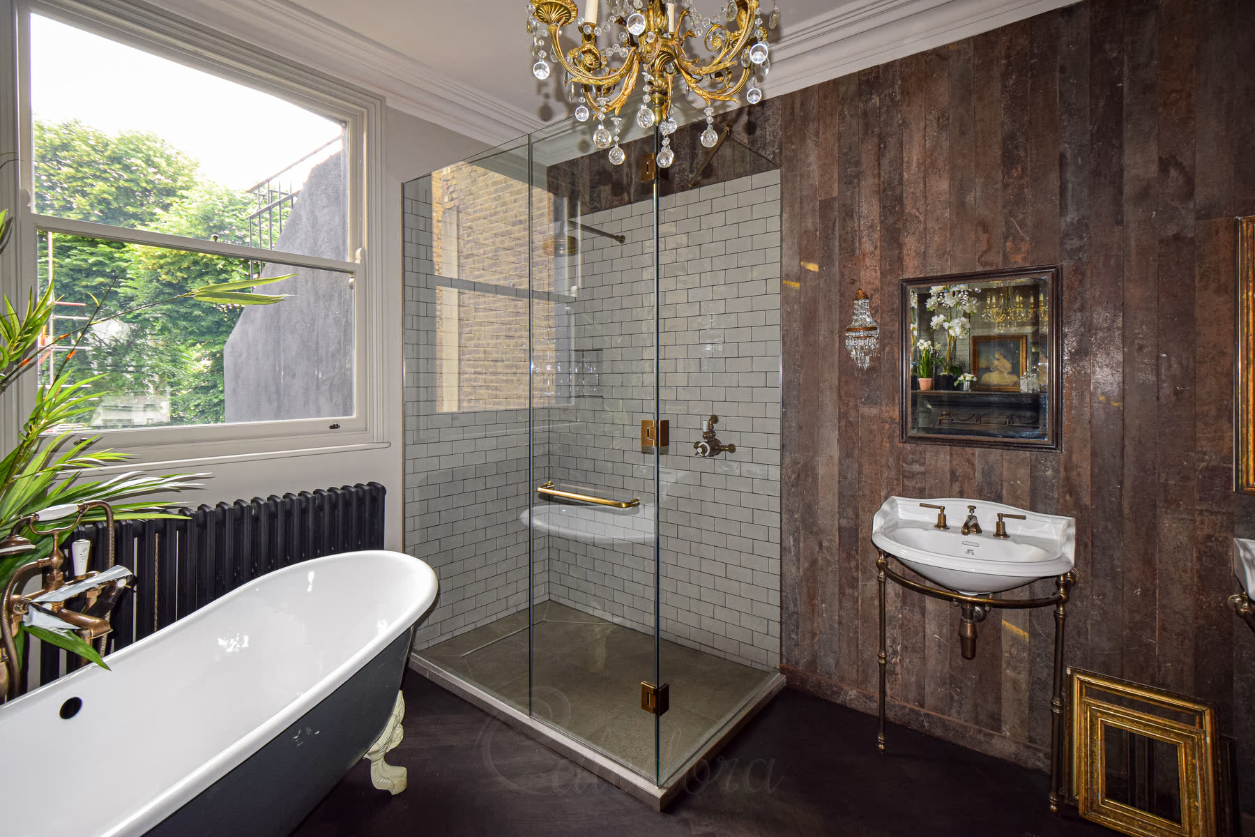 Overview of antique brass corner shower enclosure with stone tray and scaffolding board walls in spacious bathroom