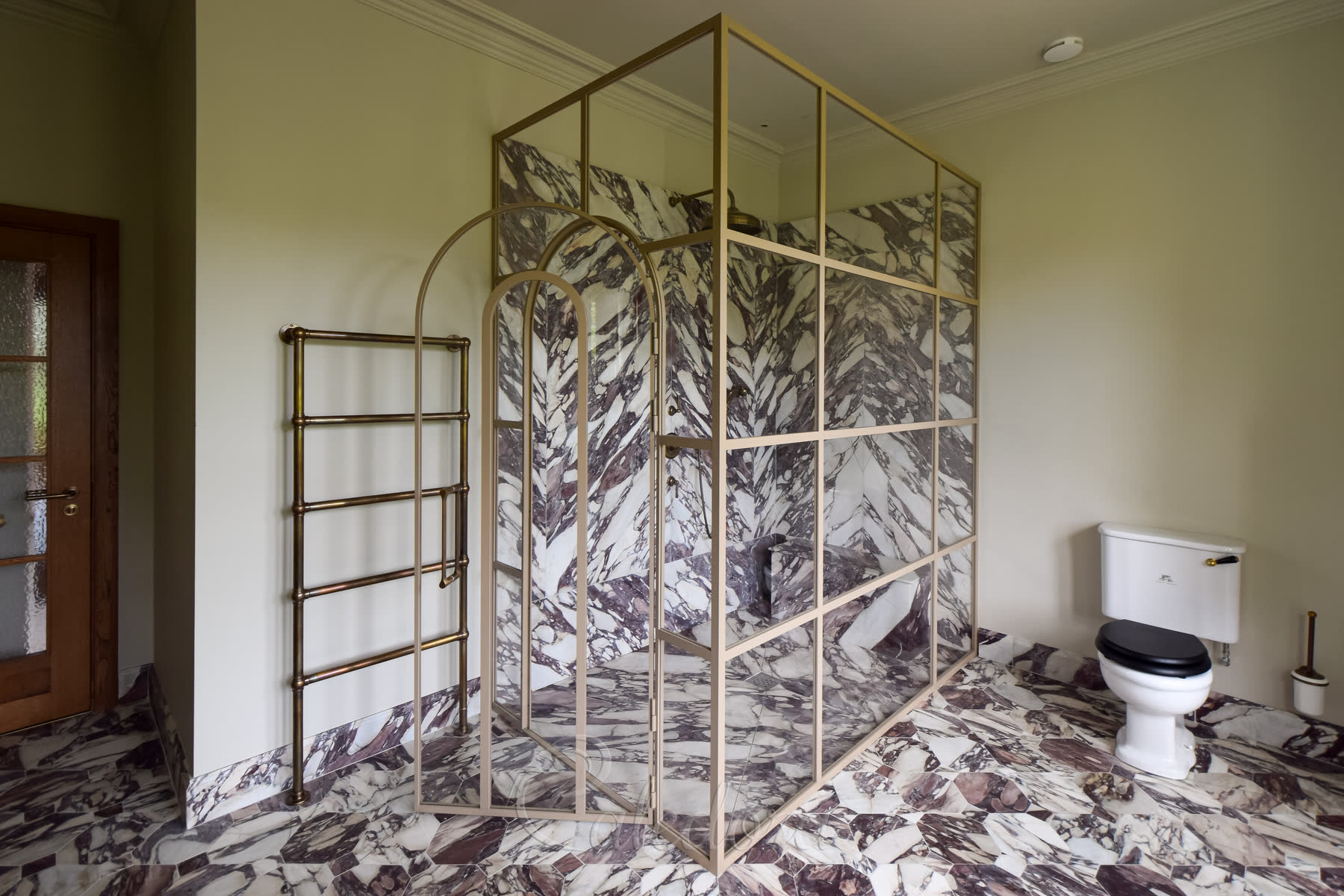 Interior view of arched shower door showing grid pattern and marble walls