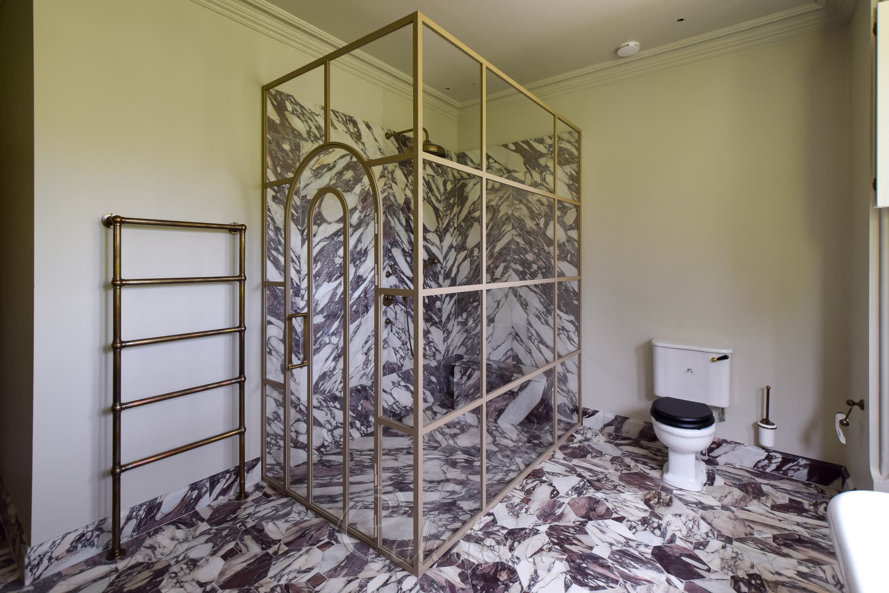 Beige framed arched shower door with elegant grid pattern in London bathroom