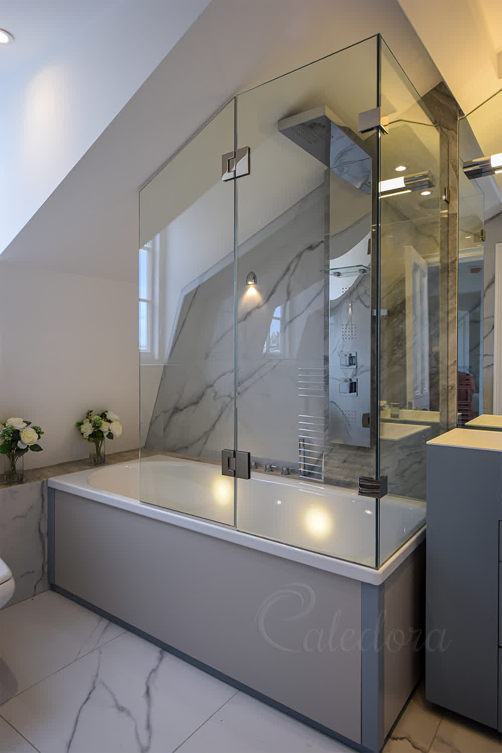 Bath shower enclosure with hinged shower door over bath and fixed panels in London bathroom