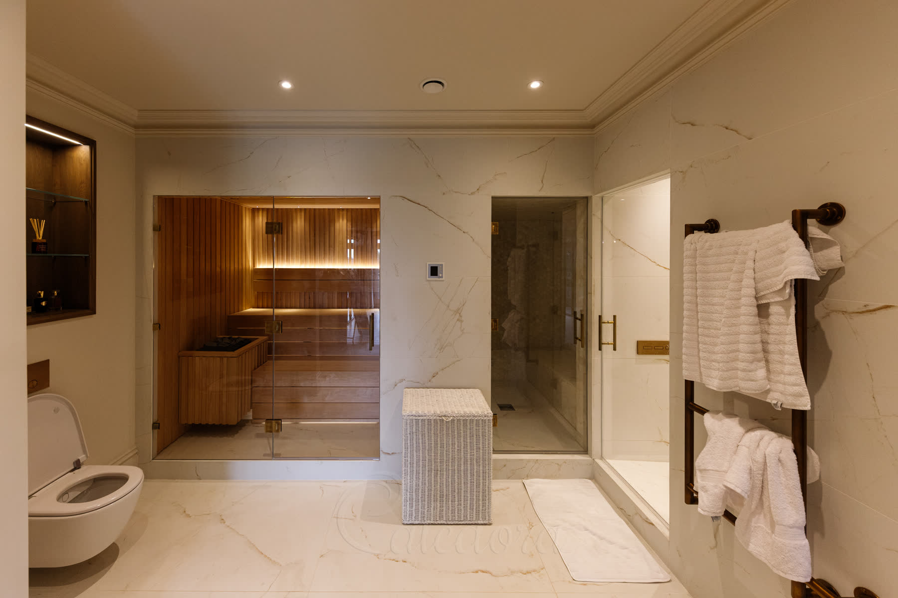 Wide view showing sauna, steam room and shower together in one suite