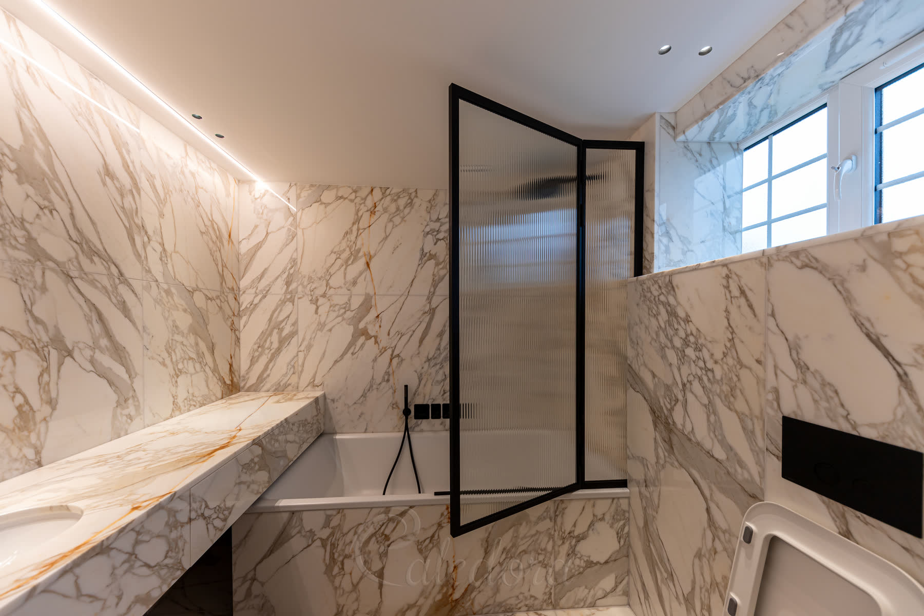 Black framed bath screen with reeded glass perfectly matching black bathroom fixtures