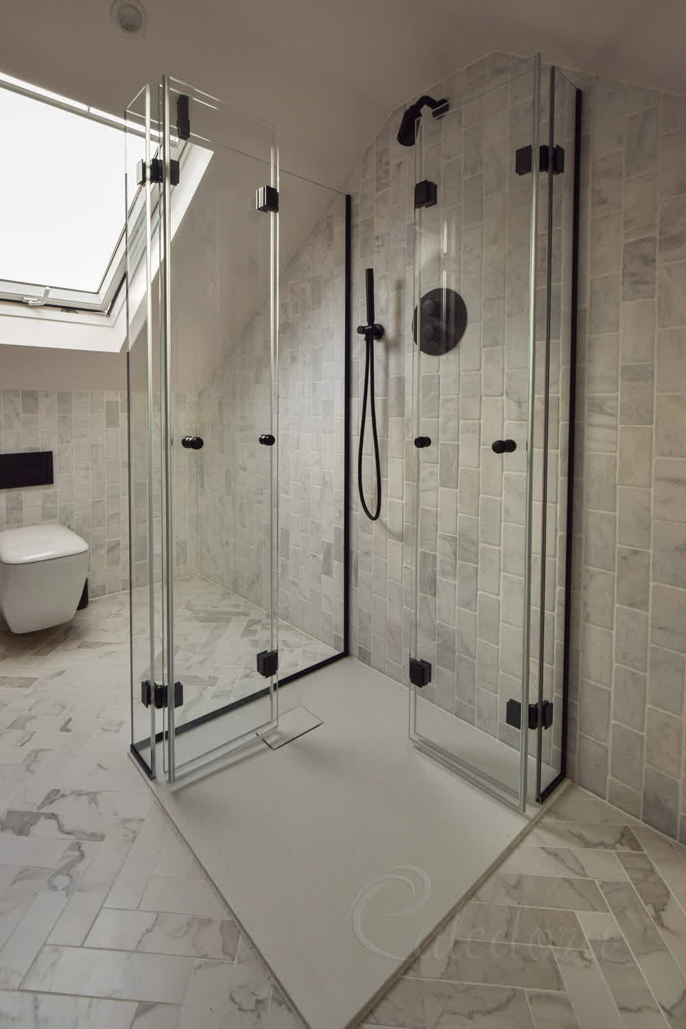 Black corner bifold shower enclosure with custom arm, spring hinges, and slim fixings installed in loft bathroom