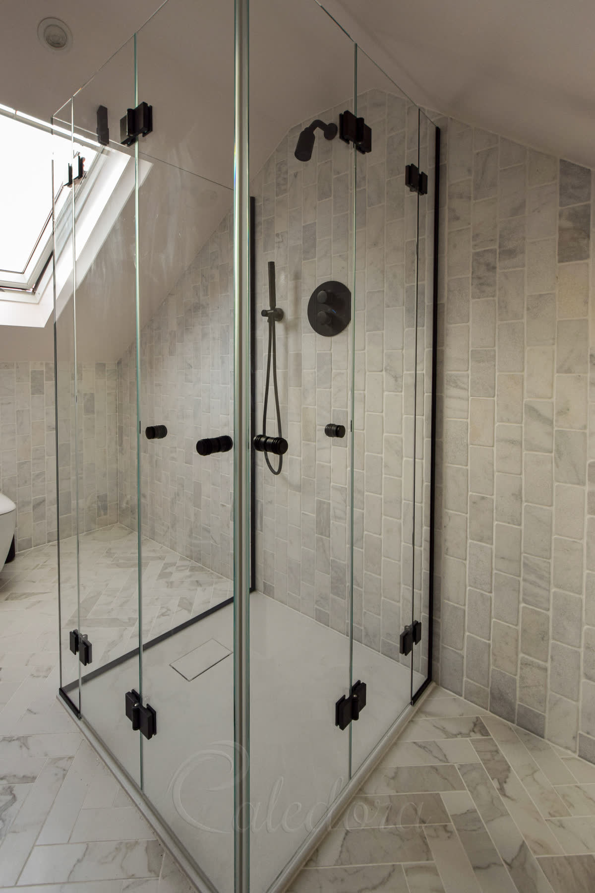Black bifold shower door folded against wall to maximize space in compact bathroom