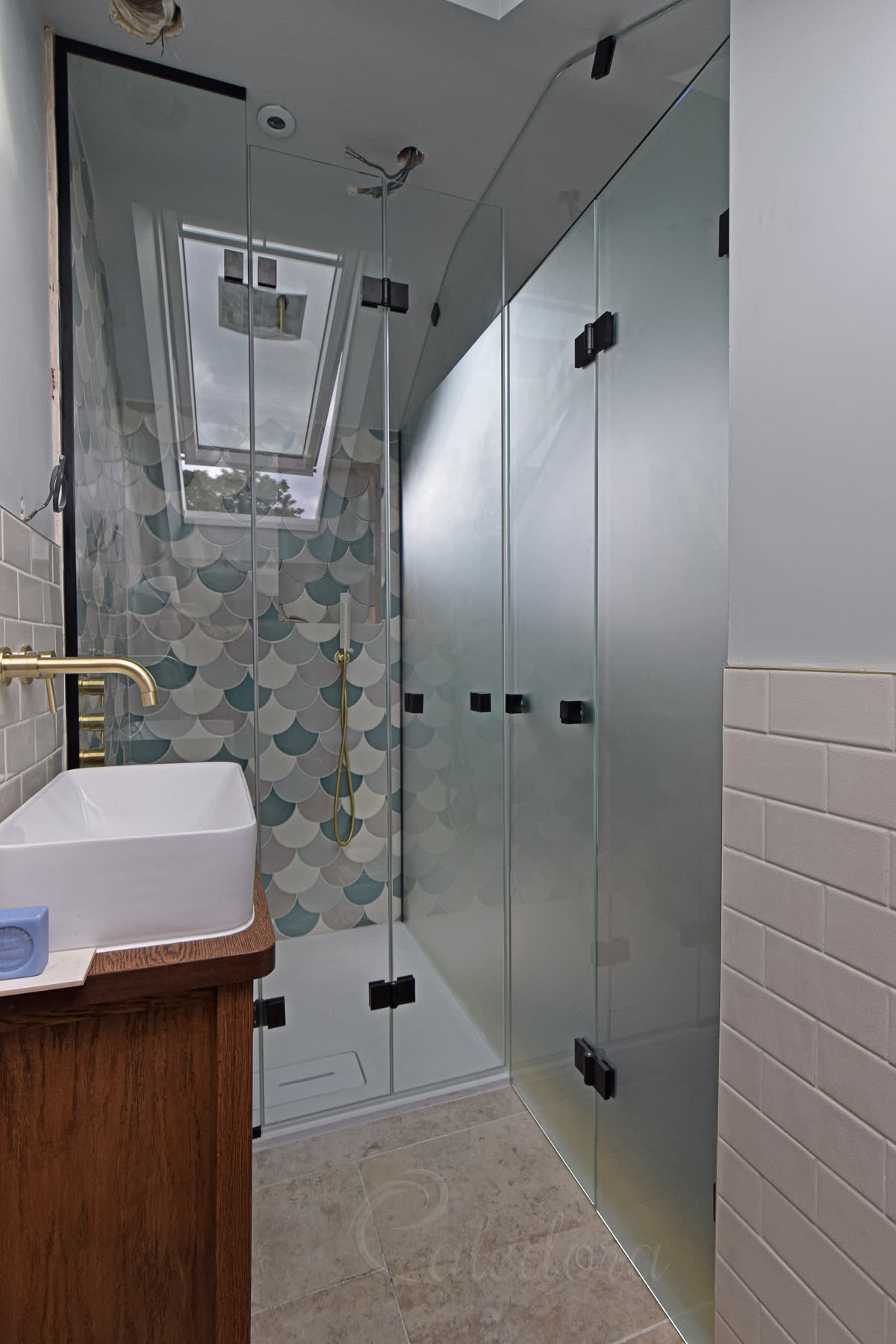 Black folding shower partition with frosted and clear glass in London loft