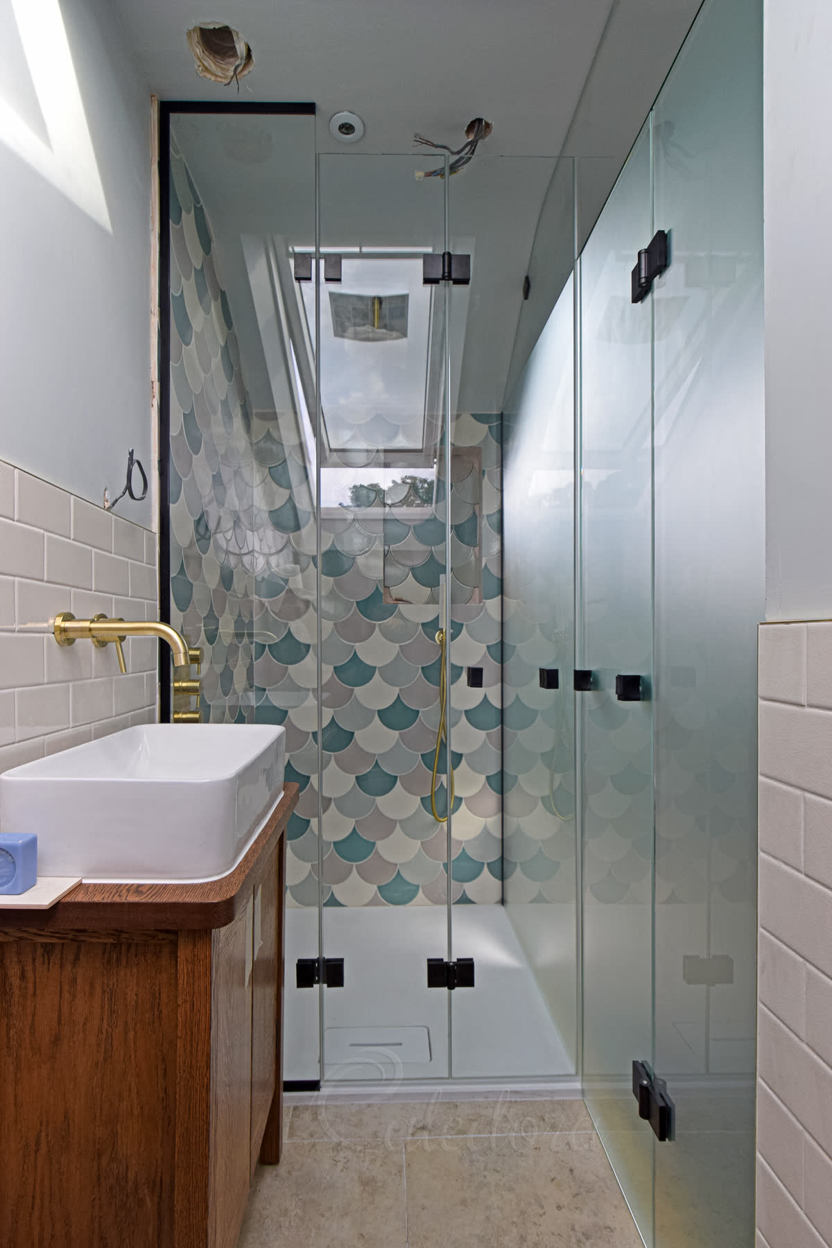 Black shower enclosure with clear glass bifold doors closed over white shower tray