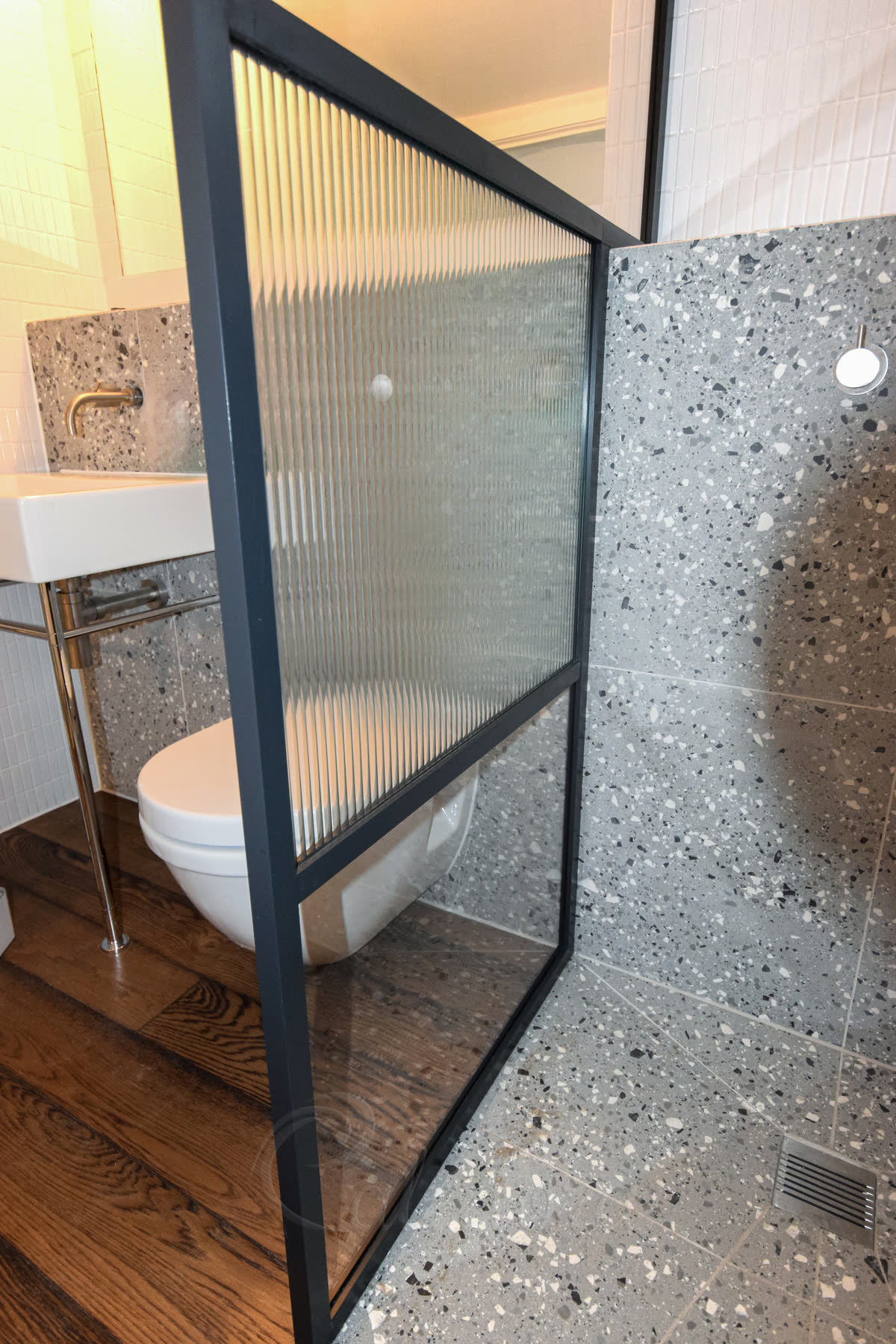 Full view of walk-in shower screen with black frame from outside showing complete installation