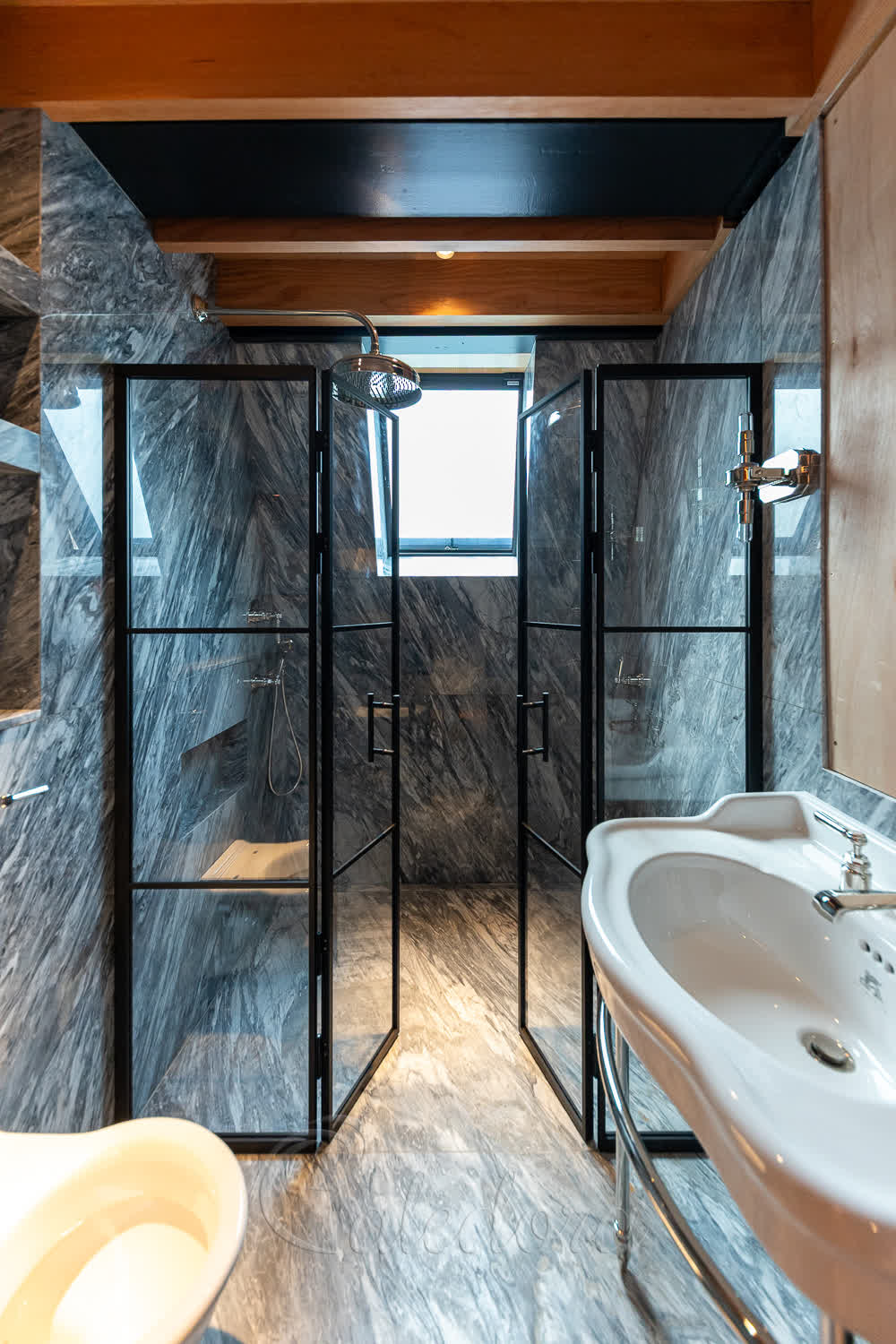 Double shower doors partially open inwards with magnetic closure system