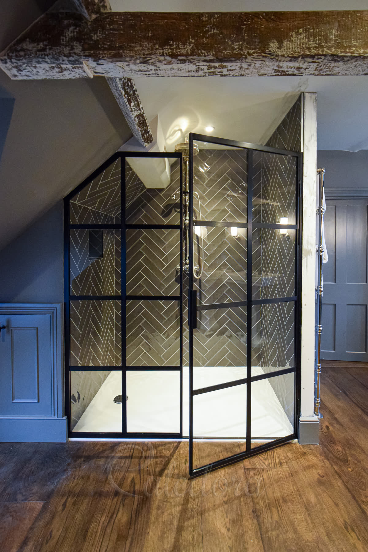 Partially open black grid shower door showing 7mm threshold and sloped ceiling adaptation