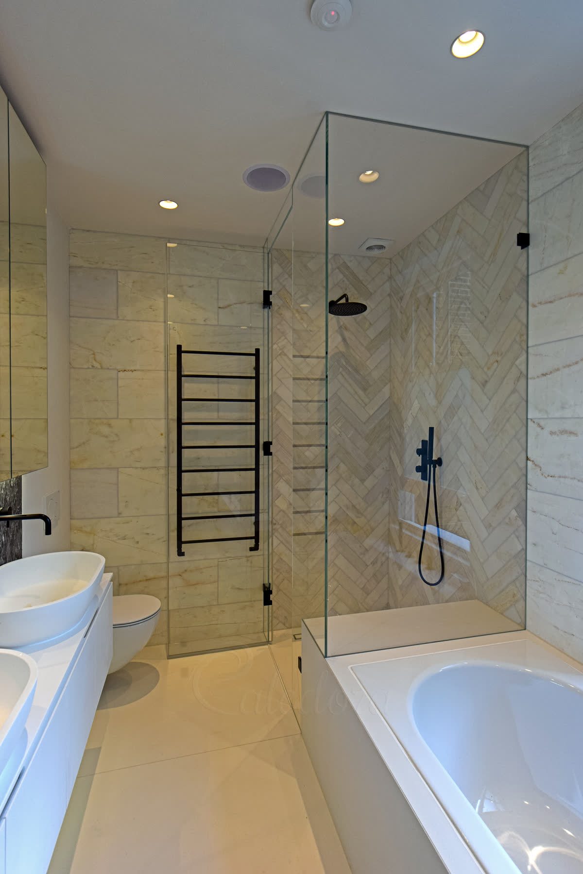 Black shower door opened outward showing towel heater clearance and bath integration