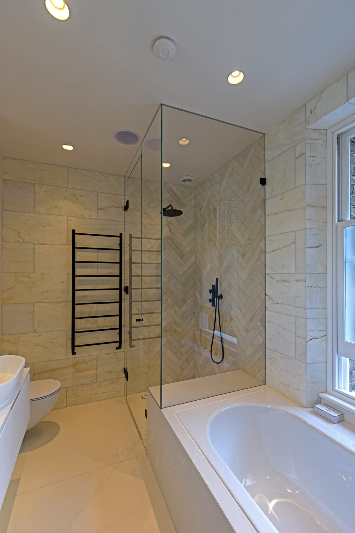 Black over bath shower enclosure side view displaying minimal wall bracket installation