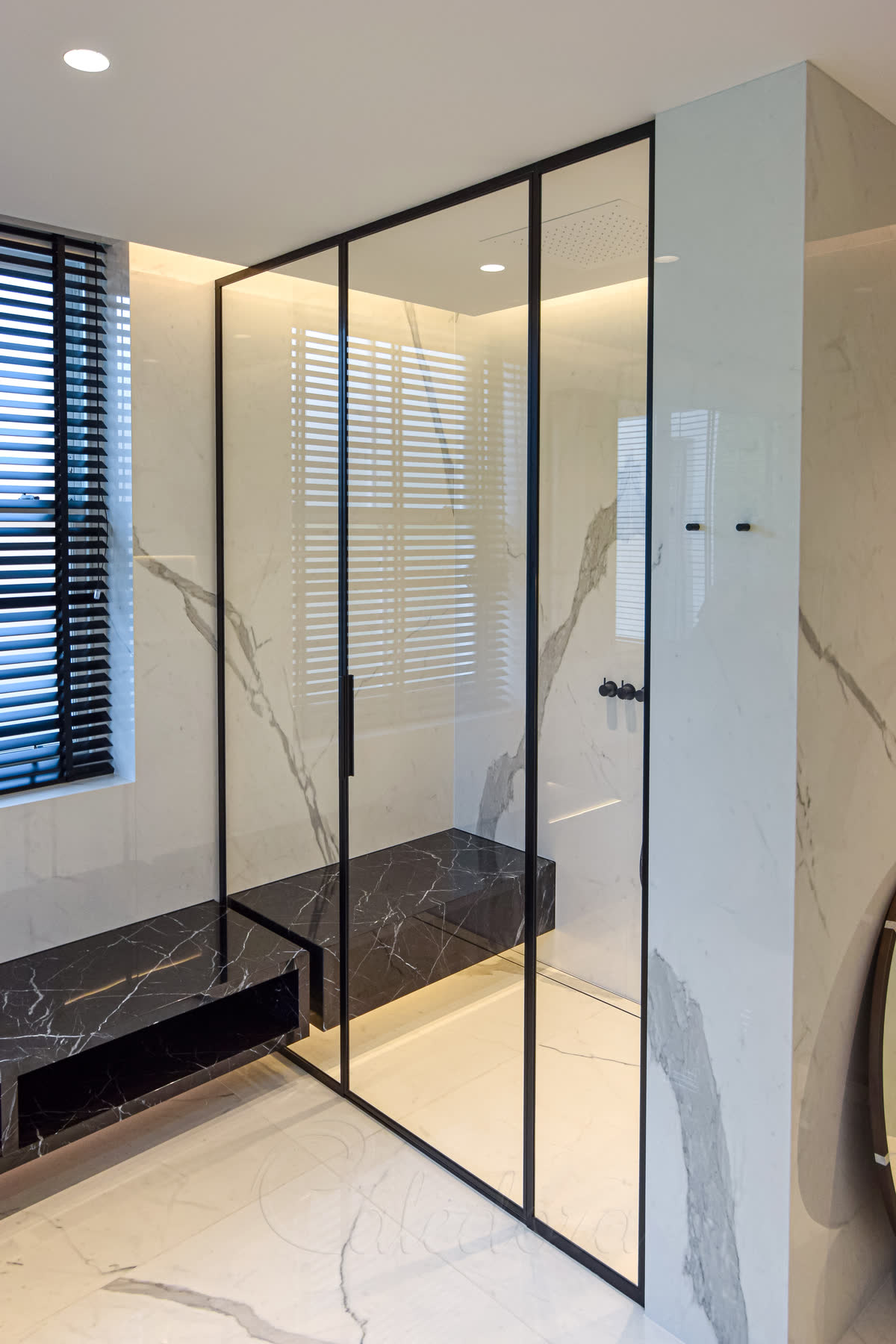 Slim black shower frames with hinged door in luxury London bathroom