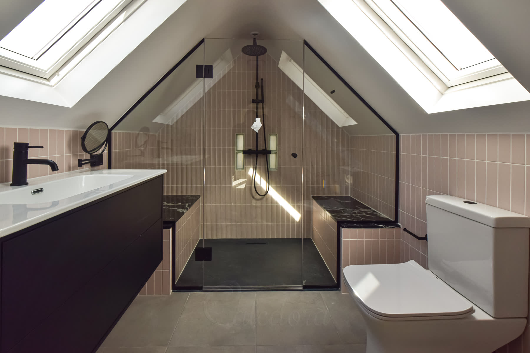 Black shower enclosure under eaves with frameless door and custom-shaped fixed panels