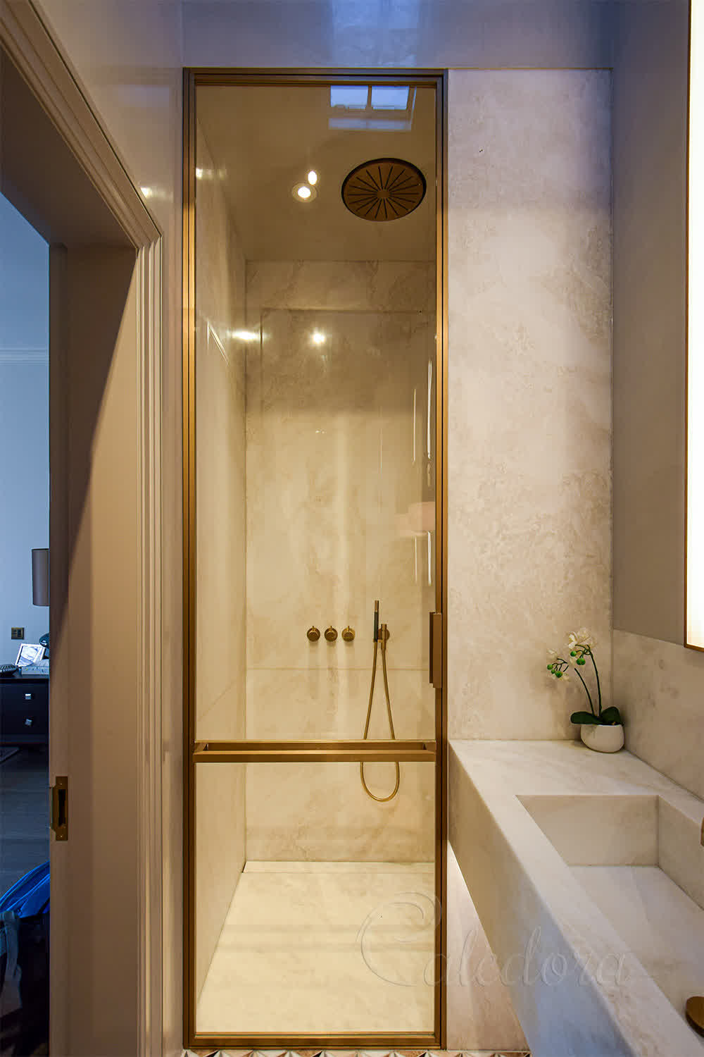 Brass-framed shower door with custom towel rail and full-height swing layout installed in London