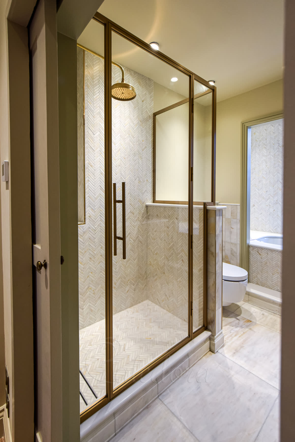 Ultra clear glass in antique brass shower enclosure with hidden hinges and seals
