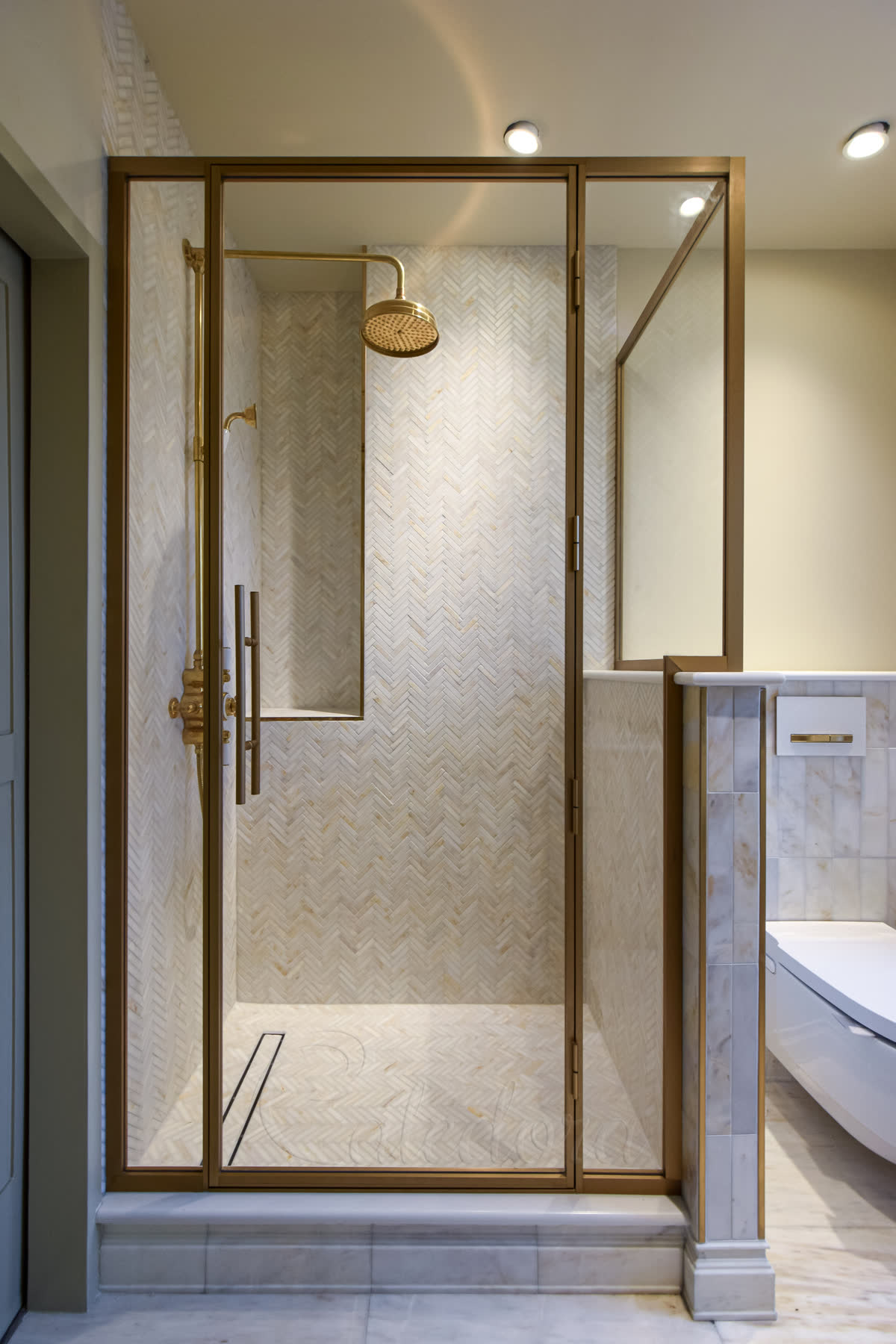 Corner antique brass shower enclosure with full height installation in marble bathroom