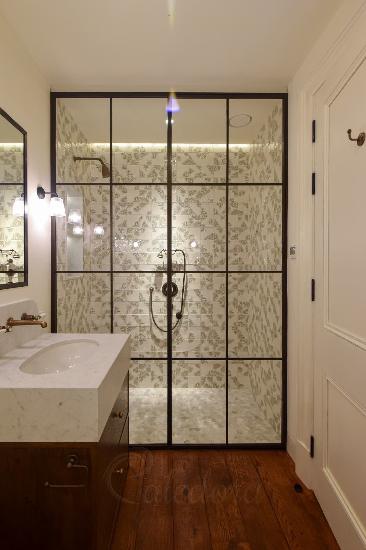 Full-height bronze shower enclosure with inward-opening door and ultra clear glass