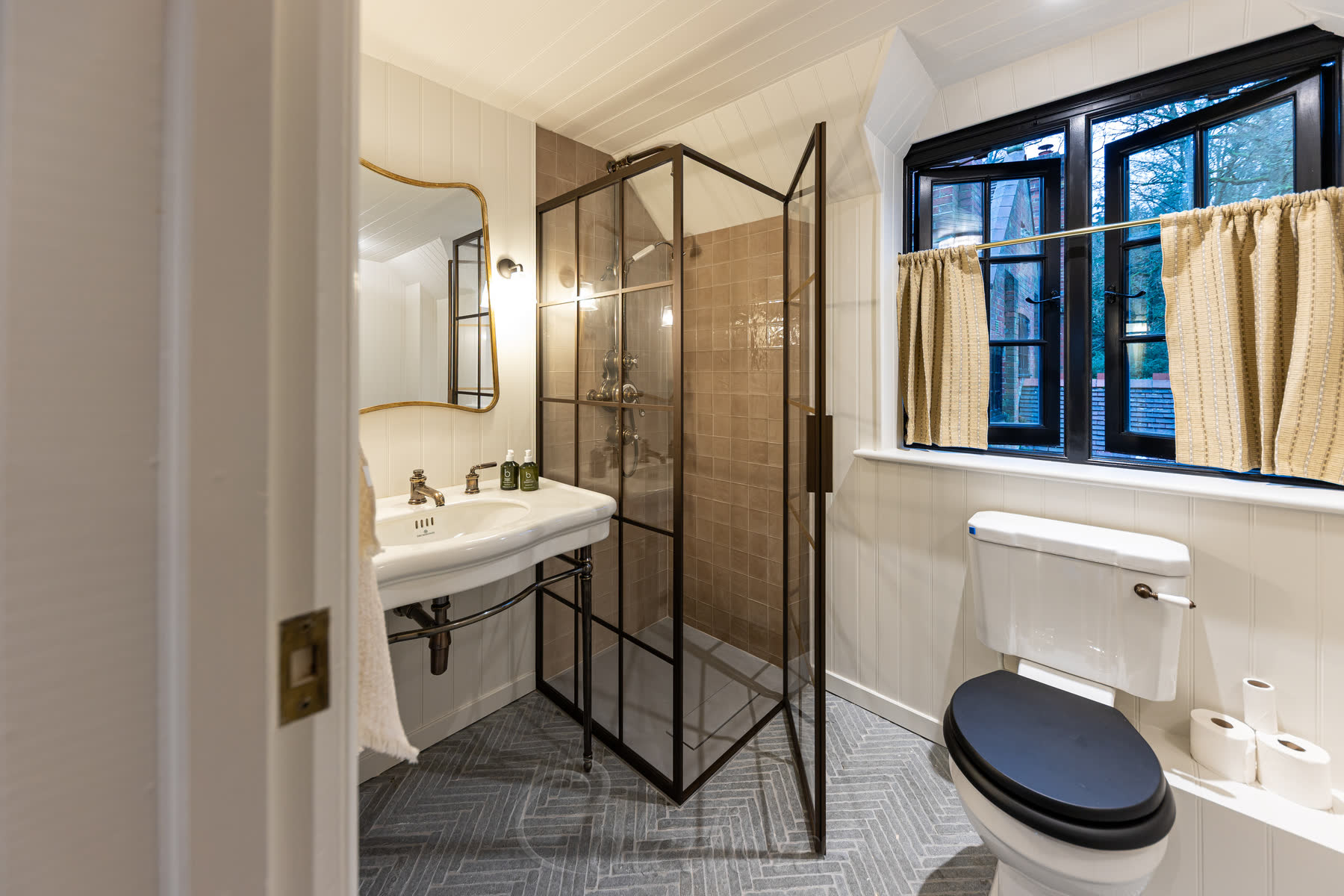 Interior view of the bronze grid shower enclosure showing the detailed grid pattern and door handle