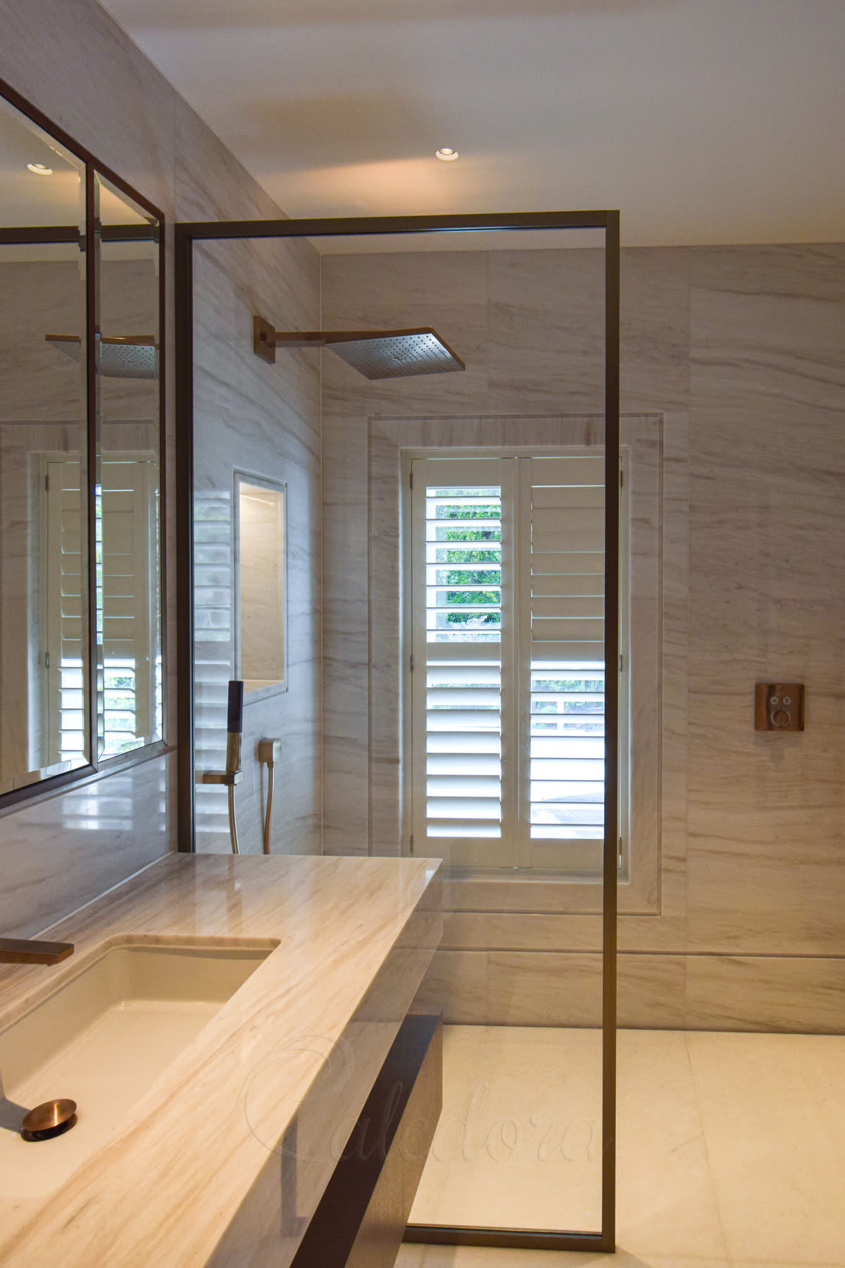 Slim framed bronze shower panel aligned with vanity unit and tiled tray