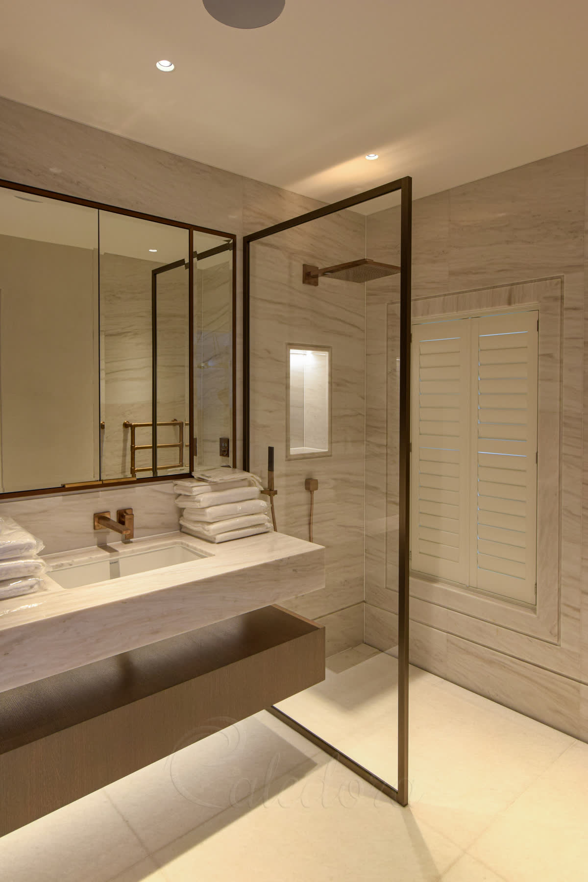 Polished bronze frame shower screen with hidden fixings and no top bar