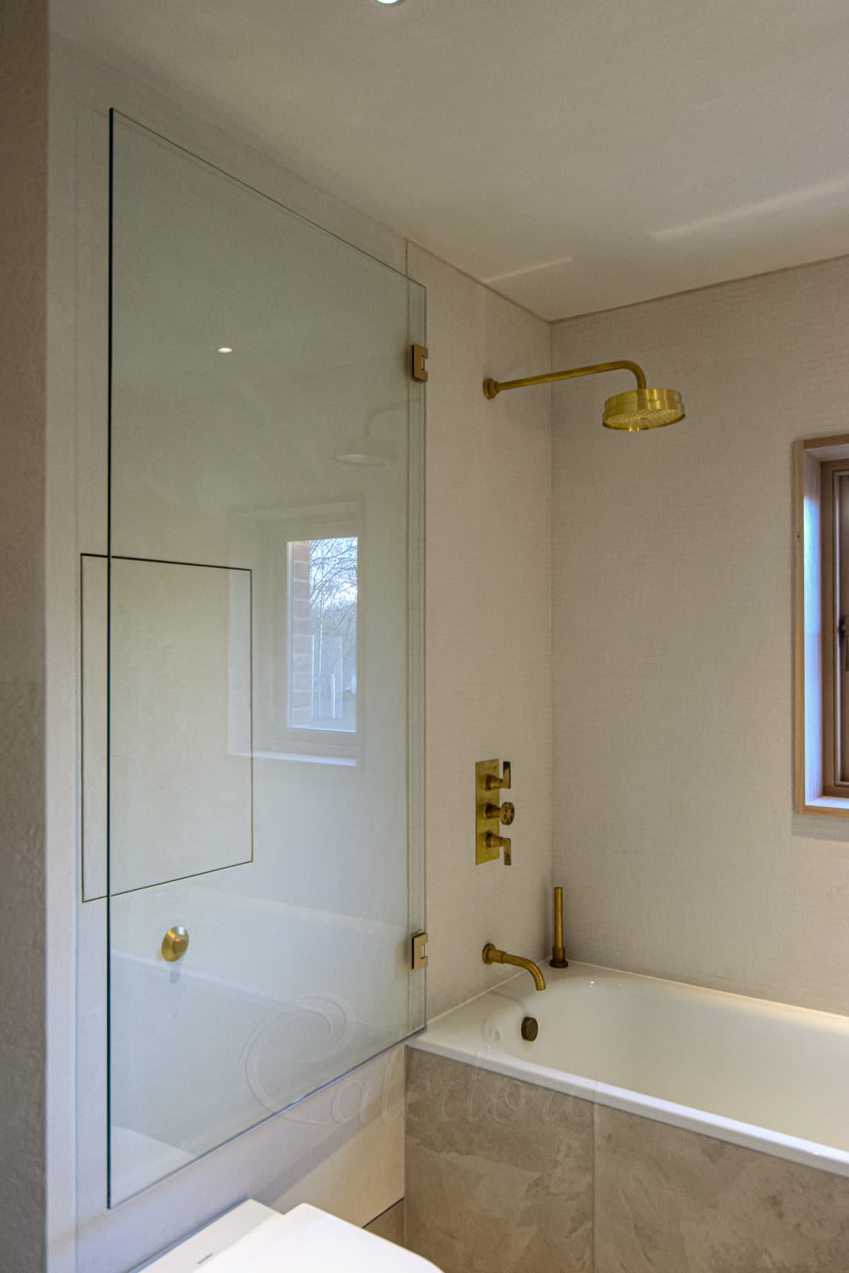 first bathroom showing brushed brass bath screen opened against wall