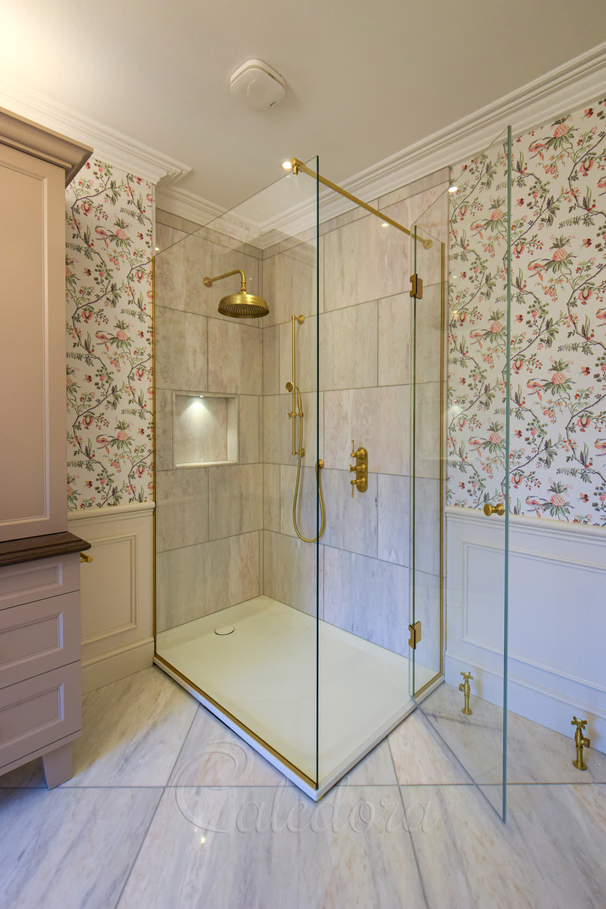 Self-centring brass hinges securing frameless shower door in a bathroom with timber panels