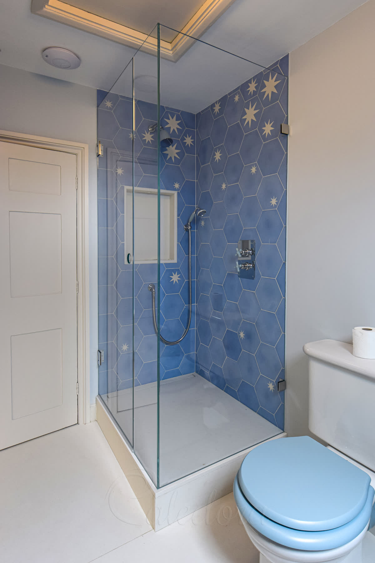 Corner chrome shower enclosure with door closed showing circular hole handle and UV-bonded panels