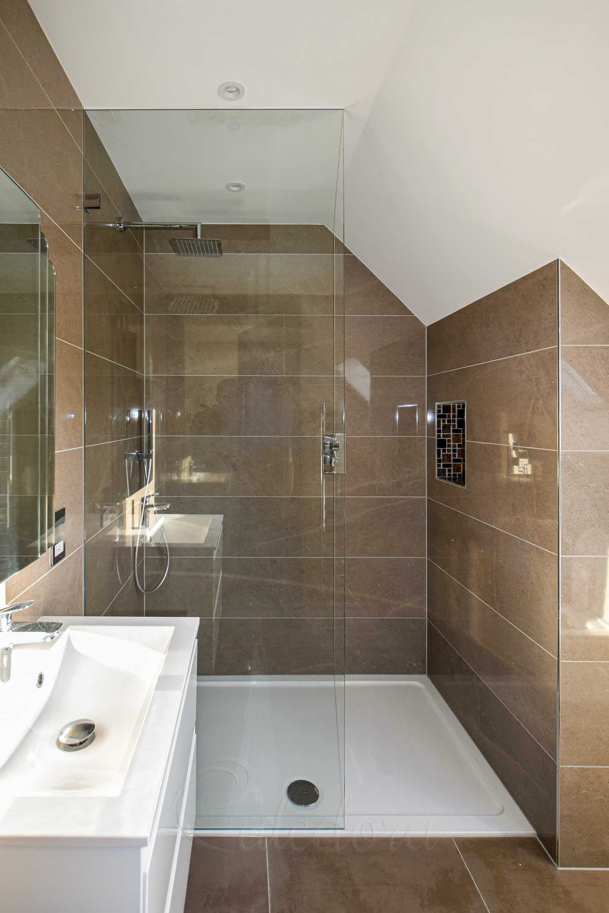 Walk-in shower screen installation showing polished chrome brackets and full-height glass panel with clear sealing