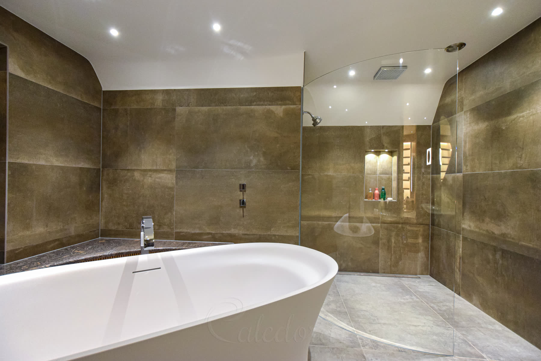 Wide angle view of curved shower screen installation next to freestanding bathtub