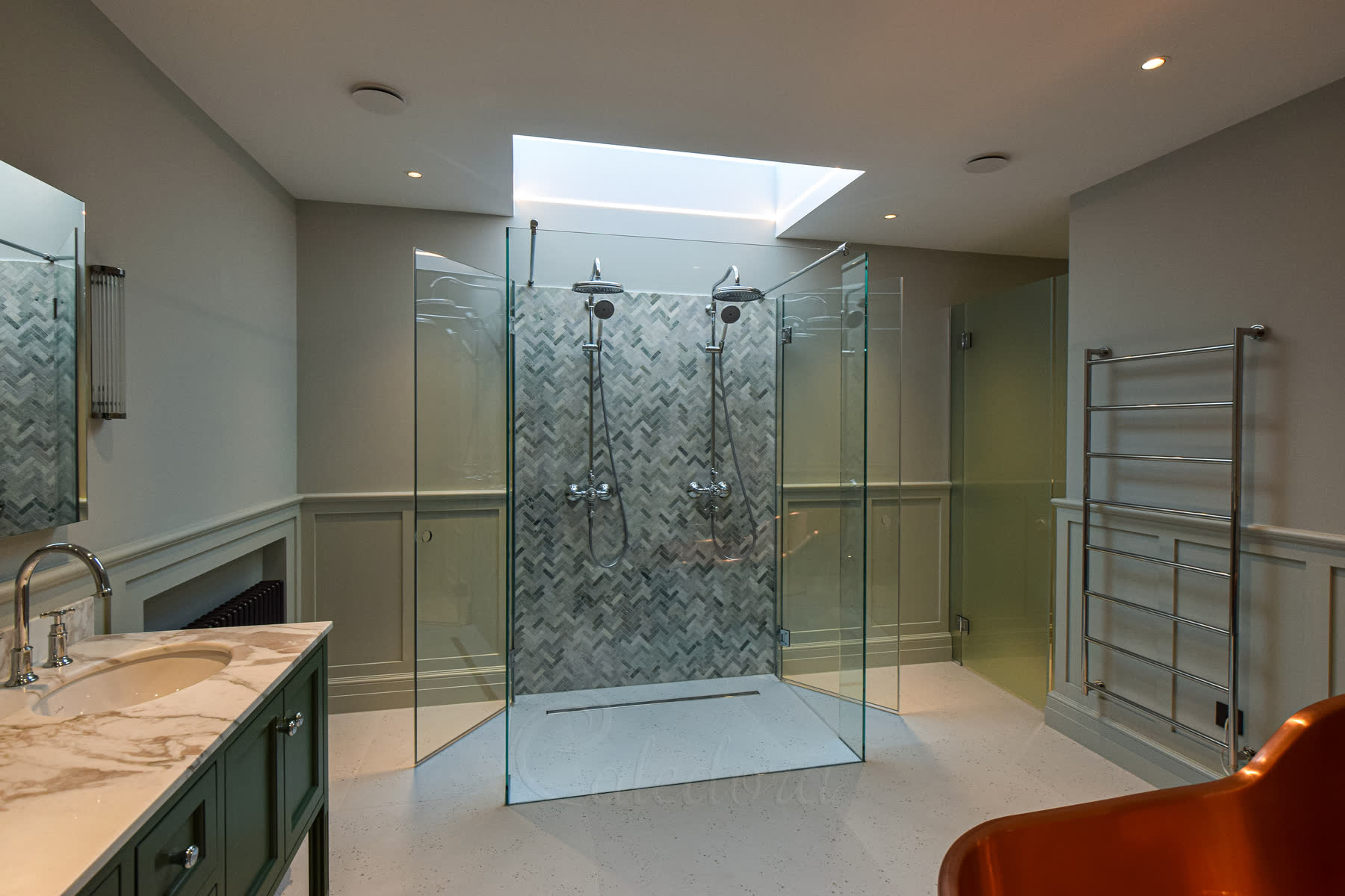 Complete bathroom view showing double shower enclosure, copper bath, and green wall paneling