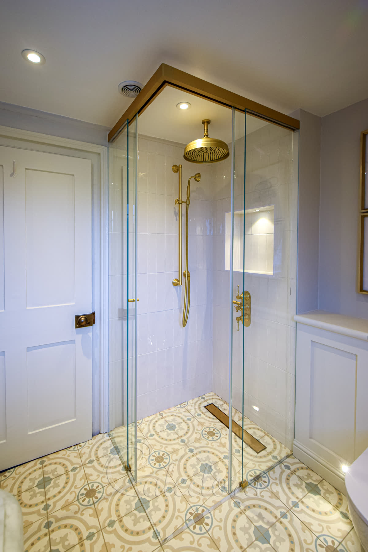 Corner entry sliding shower enclosure with satin brass finish and open doors in Bath