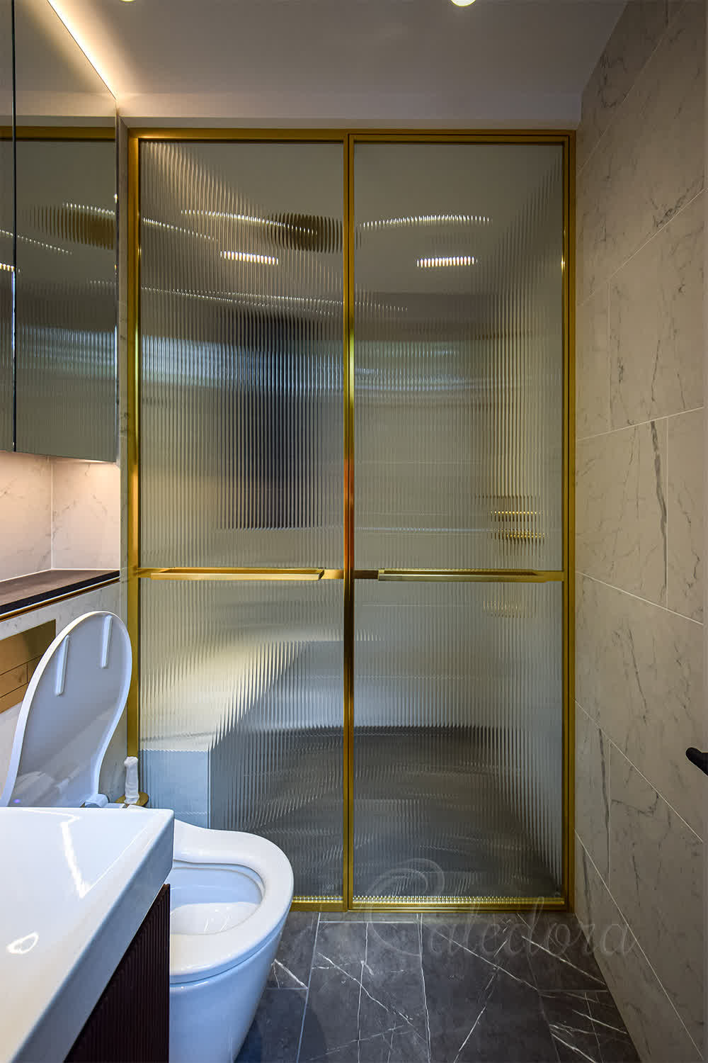Traditional brass-framed fluted glass shower door with matching fixed panel and full perimeter frame installed in London