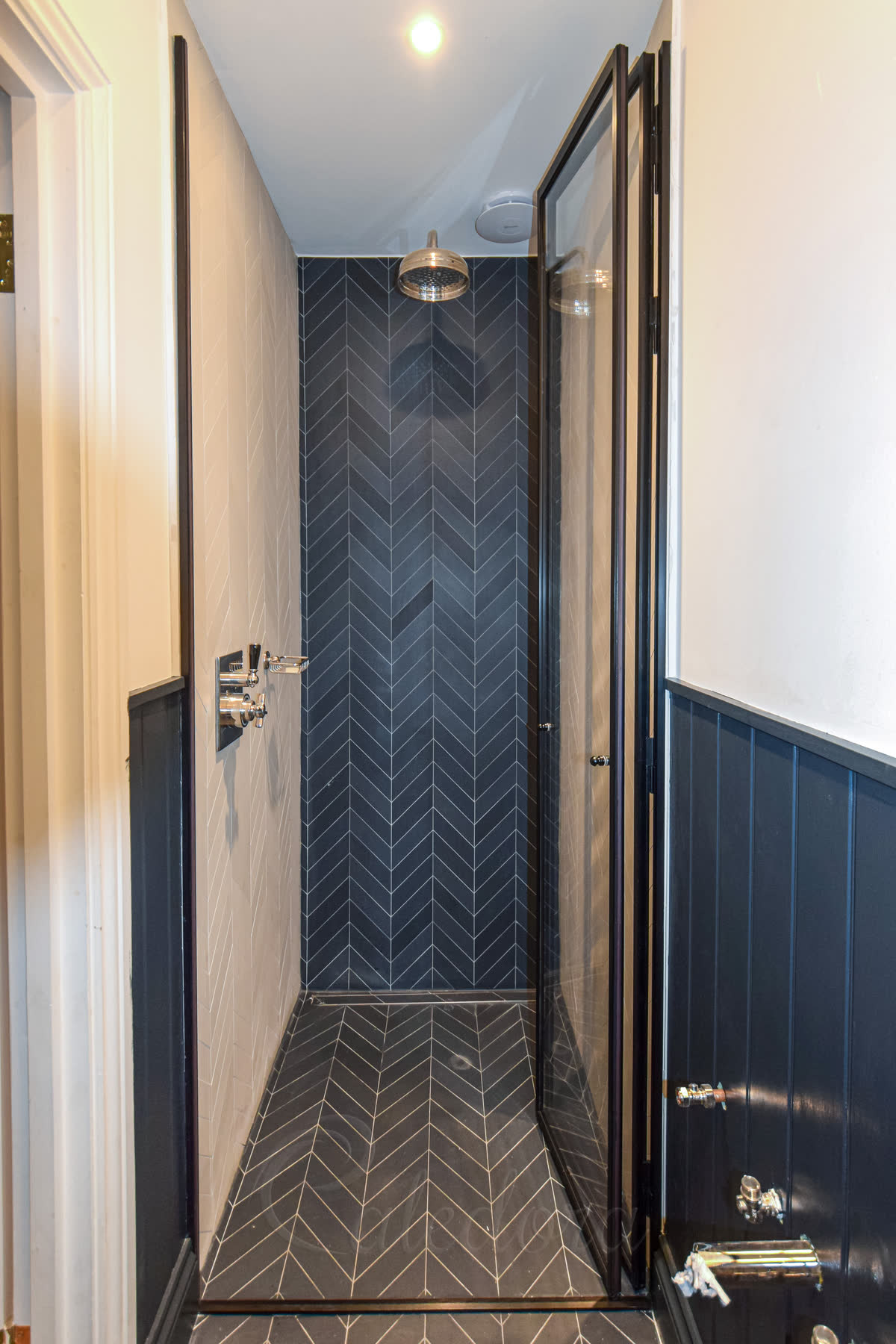 Open black framed folding shower door showing interior shower space
