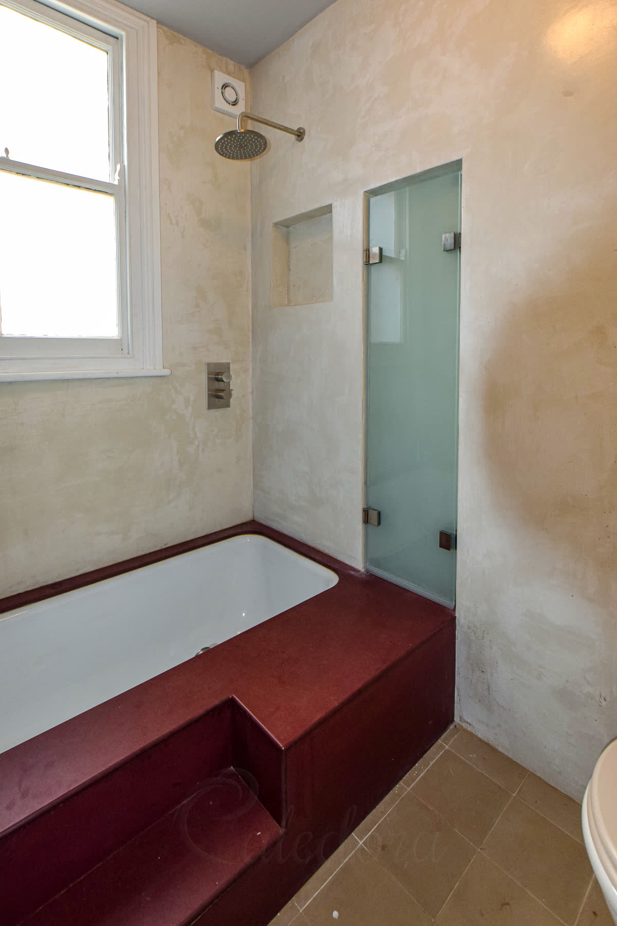 Folding shower screen partially opened showing the bath area and screen mechanism