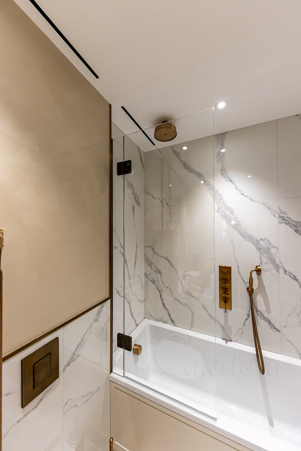 Frameless bath screen with glass-to-glass hinges on stone-effect tiles