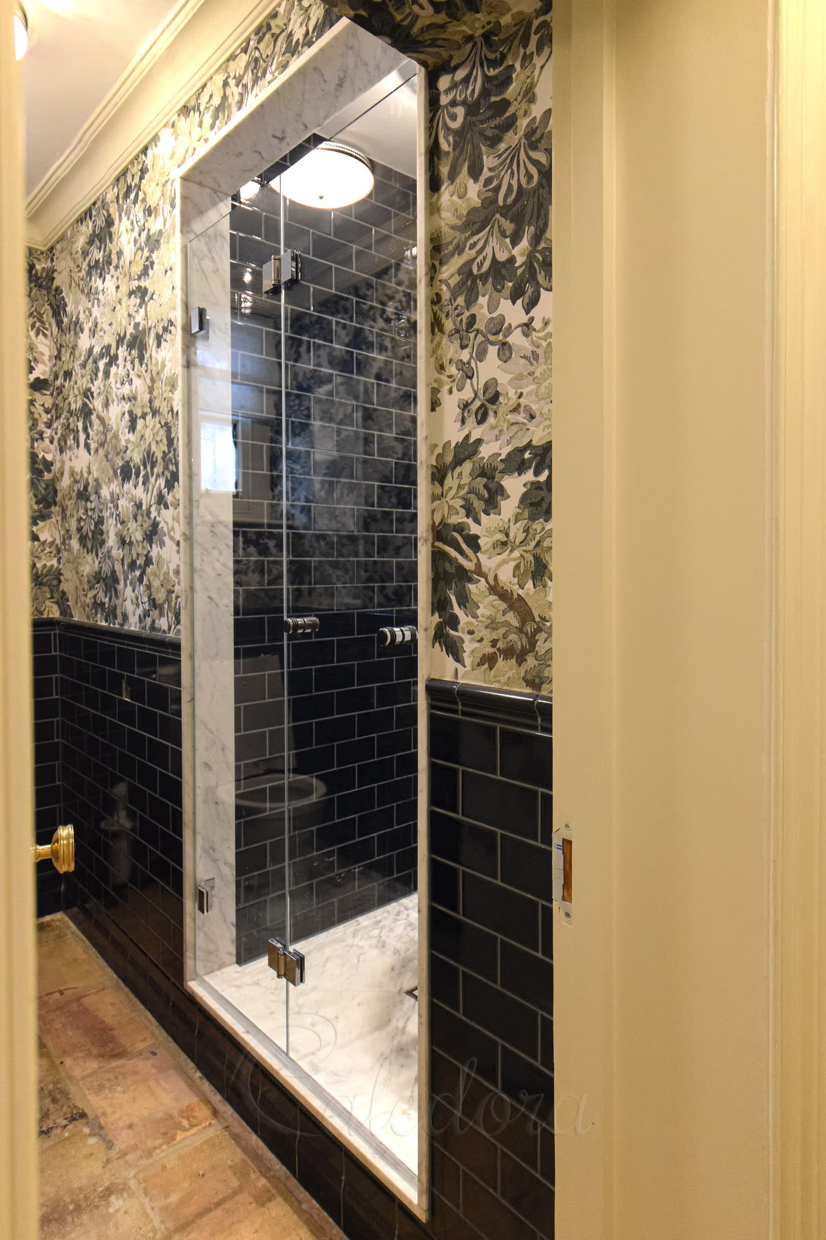 Frameless bifold shower door with chrome hinges in London bathroom